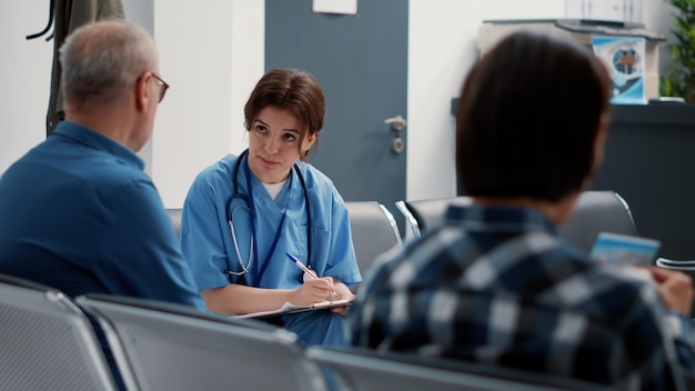 Medical assistant doing consultation with senior patient in
waiting area