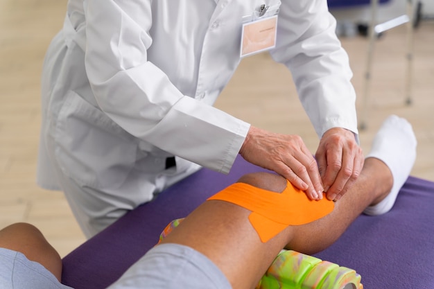 Photo medical assistant helping patient with physiotherapy exercises