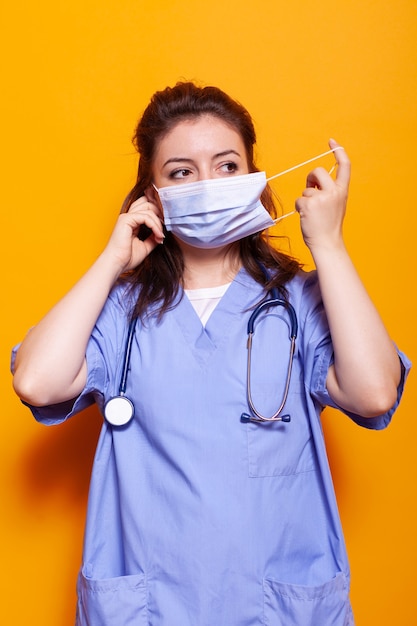 Medical assistant putting on face mask for protection