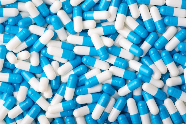 Medical background of big pile of blue and white capsules