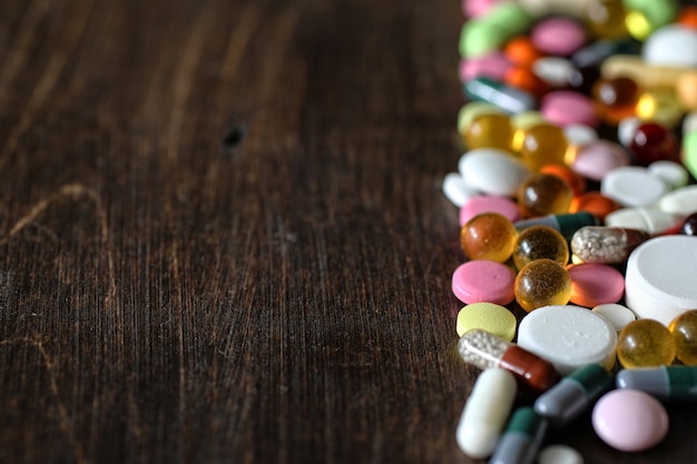 Медицинский фон различных красочных лекарств на текстурированном деревянном