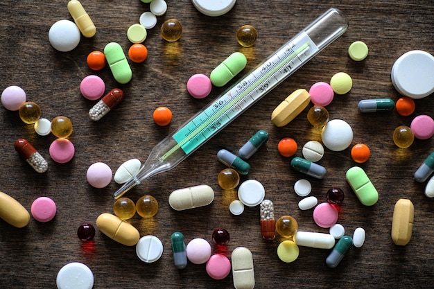 Medical background of various colorful medications on a textured wooden