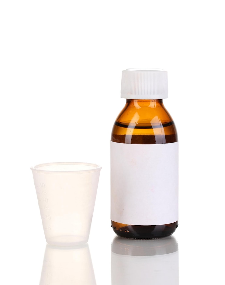 Photo medical bottle and jigger isolated on white