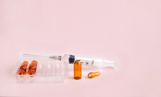 Medical bottles of brown glass with a medicinal solution ampoules and a syringe