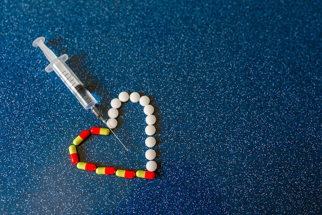 Medical bottles syringe and tablets on light gray background