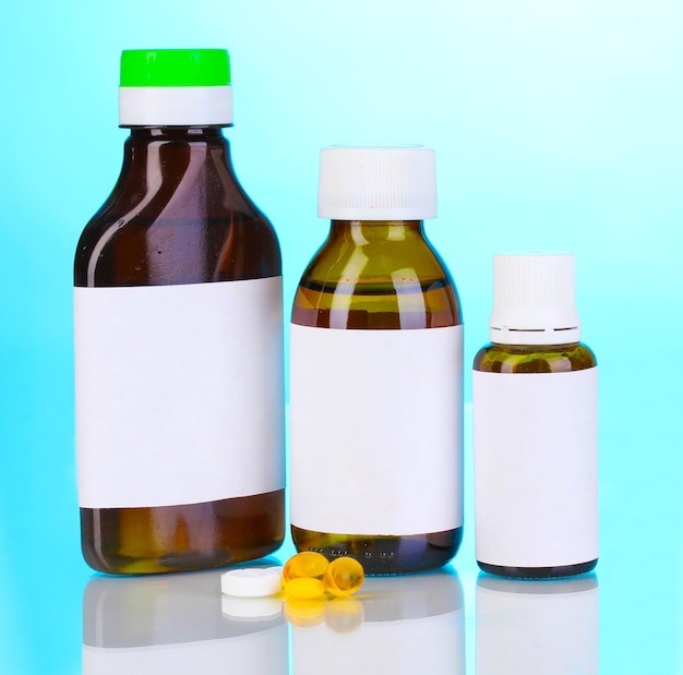 Medical bottles and tablets on blue background