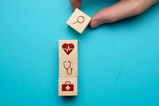 Medical care search concept with icons on wooden blocks.