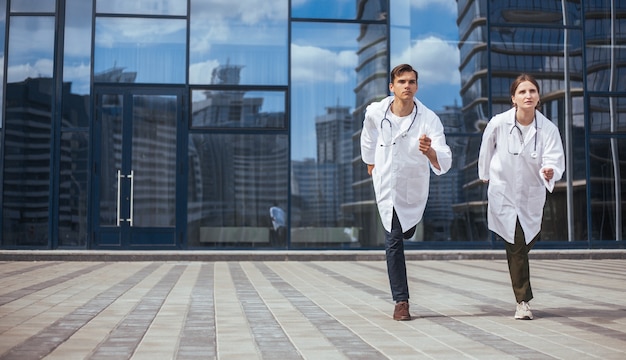 Photo medical colleagues run down a city street to an emergency call. photo with a copy-space.