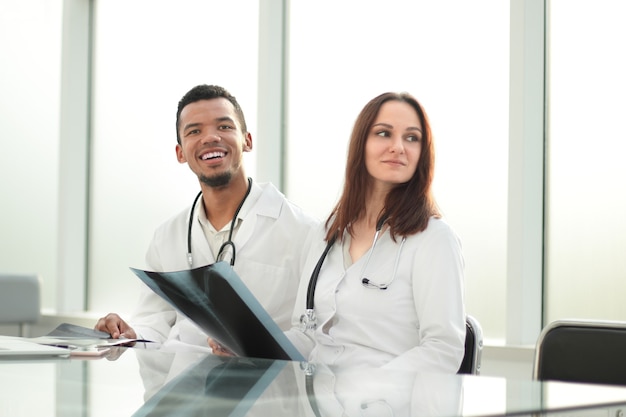 Medical colleagues with xray sitting at the office Desk.