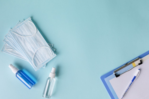 Medical concept on a blue background. Means of protection against the virus: medical mask, antiseptics, hand hygiene products, sanitizers. Copy space