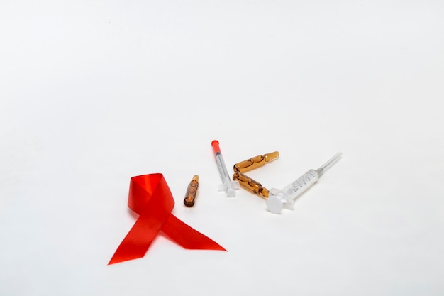 Medical concept december world aids day. Red tape, ampoules of medicine and syringe on a white background. Safe sex