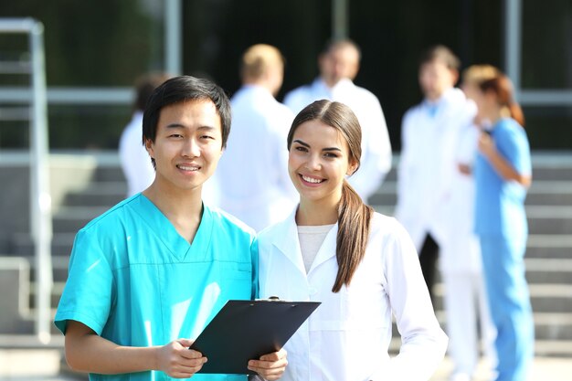 Medical concept - two doctors with stethoscopes and prescription clipboard