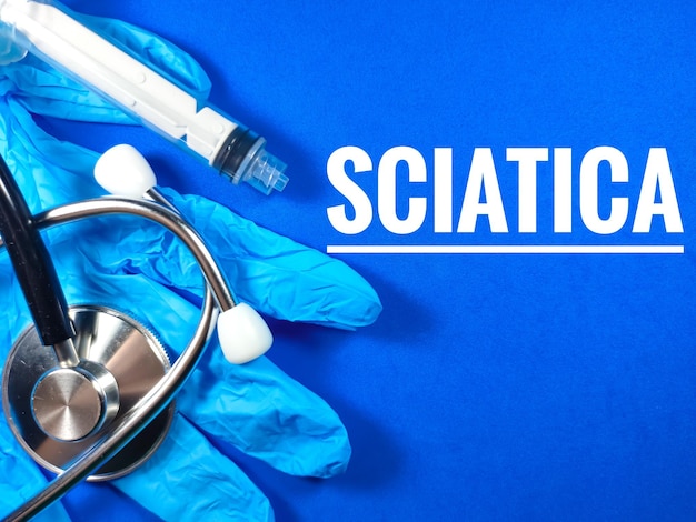 Medical conceptText SCIATICA met nitrilhandschoenenspuit en stethoscoop op blauwe achtergrond