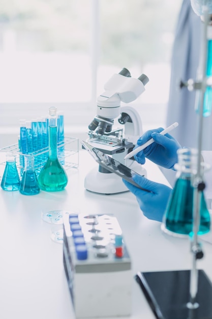 Photo medical development laboratory caucasian female scientist looking under microscope analyzes petri dish sample specialists working on medicine biotechnology research in advanced pharma lab