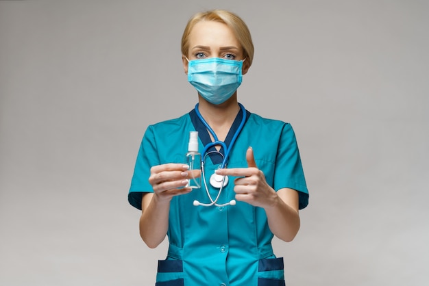 소독 스프레이 또는 젤의 보호 마스크 지주 병을 입고 의사 간호사
