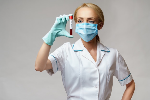 Фото Врач медсестра женщина носить защитную маску и перчатки - проведение анализа крови на вирус