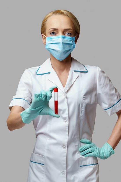 바이러스 혈액 검사를 들고 보호 마스크와 장갑을 착용 의사 간호사 여자