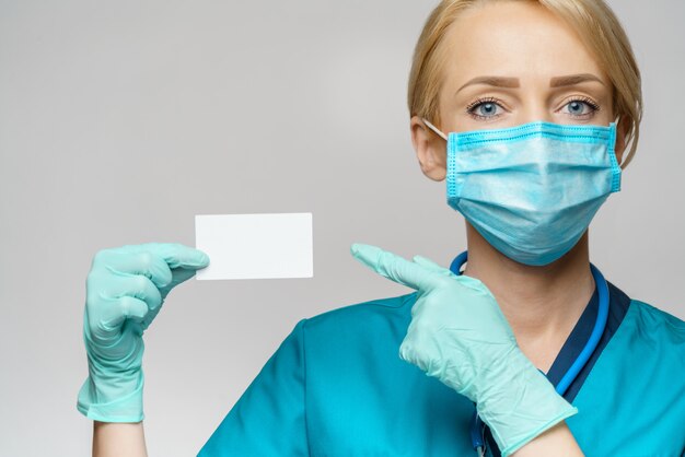 Foto donna dell'infermiere di medico che indossa maschera protettiva e guanti - mostrando biglietto da visita in bianco