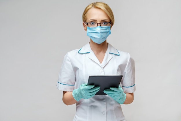 Medical doctor nurse woman wearing protective mask and gloves