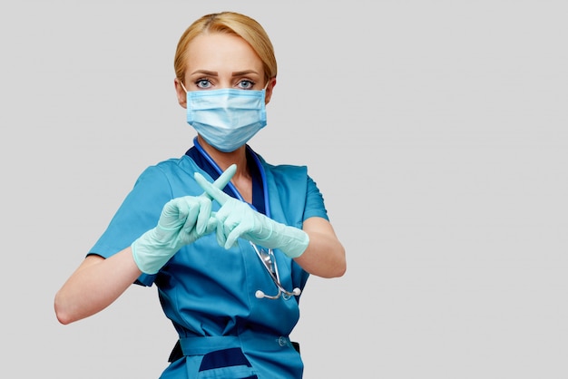 Medical doctor nurse woman with stethoscope wearing protective mask and rubber or latex gloves