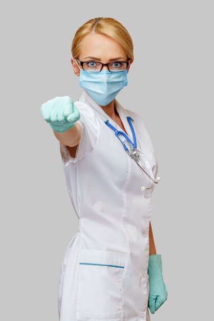 Medical doctor nurse woman with stethoscope wearing protective mask