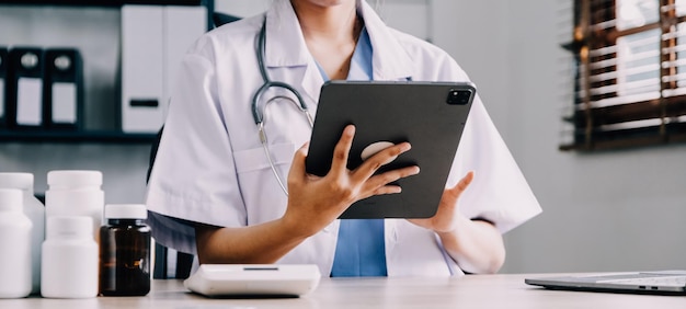전문 응급 의료 지원 서비스 개념을 위해 클리닉 또는 병원 사무실에서 인터넷 모바일 디지털 태블릿을 사용하여 온라인으로 환자의 건강을 상담하는 의사 또는 의사