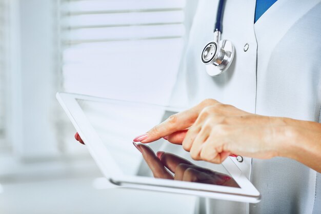 Medical doctor woman smile hold tablet pc, using computer.