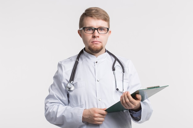 Medical doctor writing prescription over white surface.