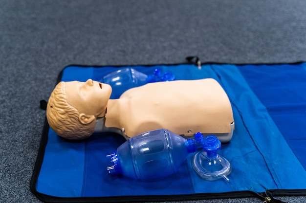 Medical doll lays on blue blanket ready for training. First medical help with oxigen masks.