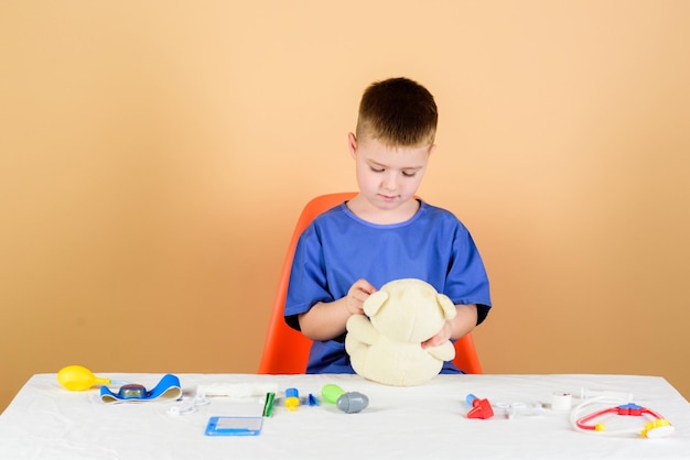 Medical education boy cute child future doctor career health
care kid little doctor busy sit table with medical tools medicine
concept medical procedures for teddy bear medical examination