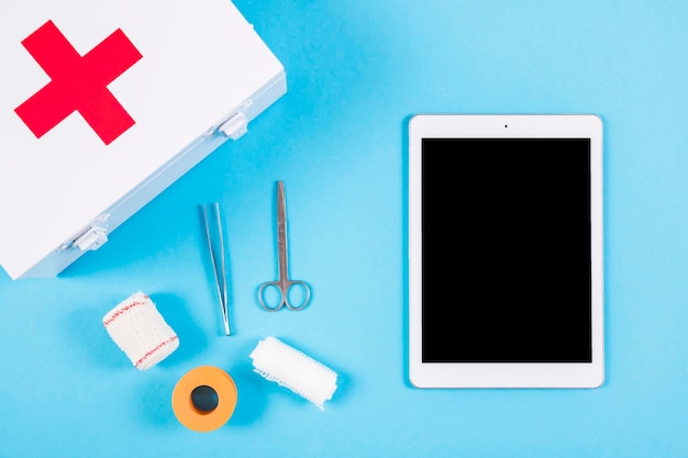 医療機器と救急キット 空白のデジタルタブレット 青い背景
