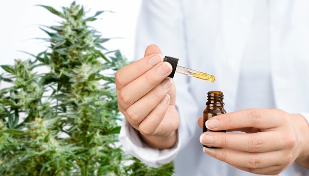 A medical expert holding a bottle of cbd oil in his hands.