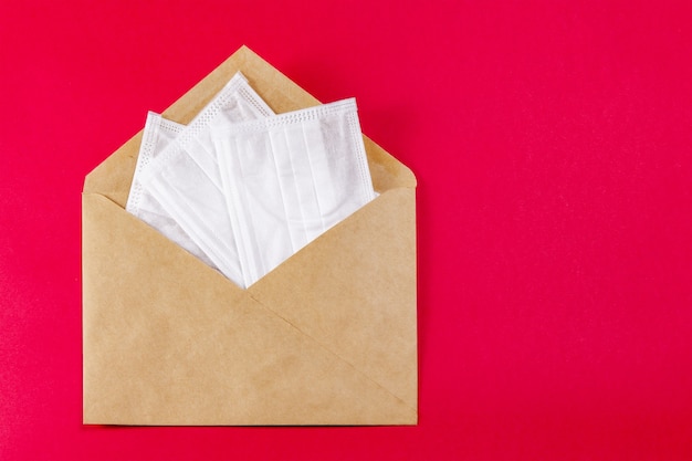 Medical face mask in a grey envelope on red