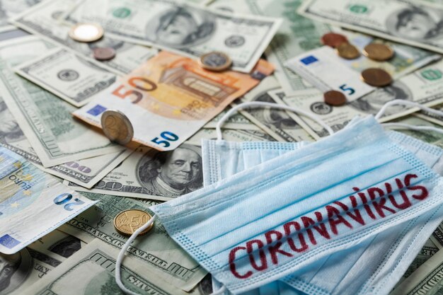 medical face mask and money world coronavirus epidemic and economic losses concept