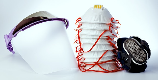 Medical face shield and protective masks on white background