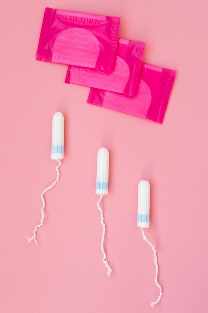 Medical female tampon on a pink . Hygienic white tampon for women. Cotton swab