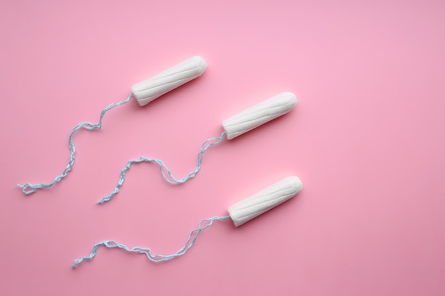 Medical female tampons on a pink background. White tampon for women.