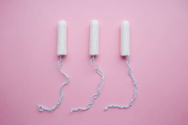 Foto tamponi femminili medici su uno sfondo rosa. tampone bianco per le donne.