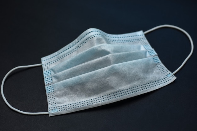 Medical gauze mask on dark background.