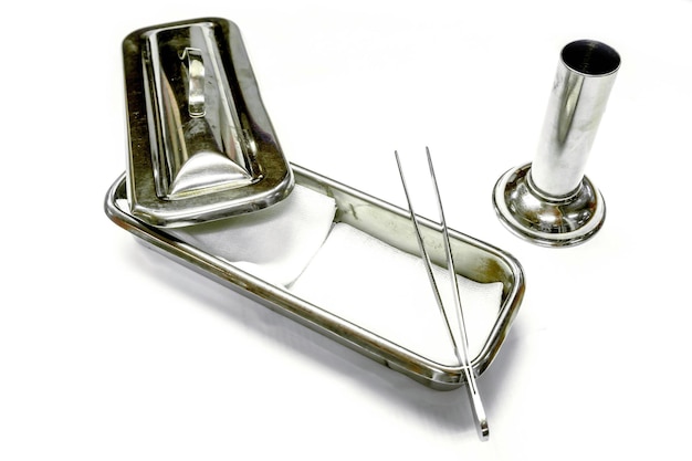 A medical gauze in a medical stainless steel container and surgical forceps in container on white background