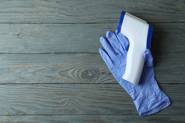 Photo medical glove and thermometer gun on wooden