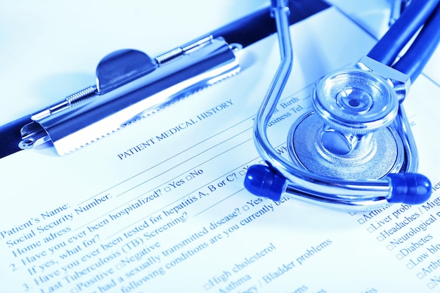 Photo medical history on clipboard with stethoscope on light background