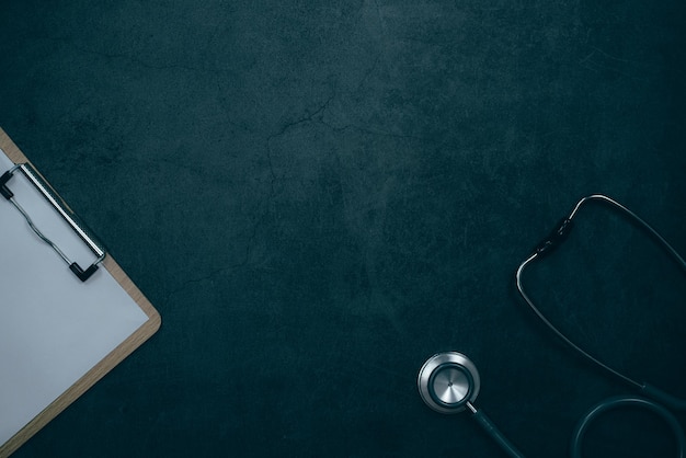 Medical history with stethoscope and clipboard on black desk