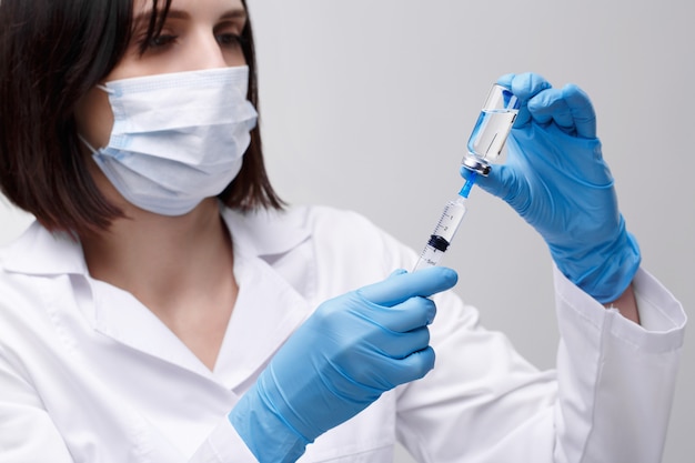 Medical injection,diseases,health care,science,diabetes.Doctor or nurse in hospital holding a syringe with liquid vaccines preparing to do an injection.Medical equipment. People in white uniform,robe