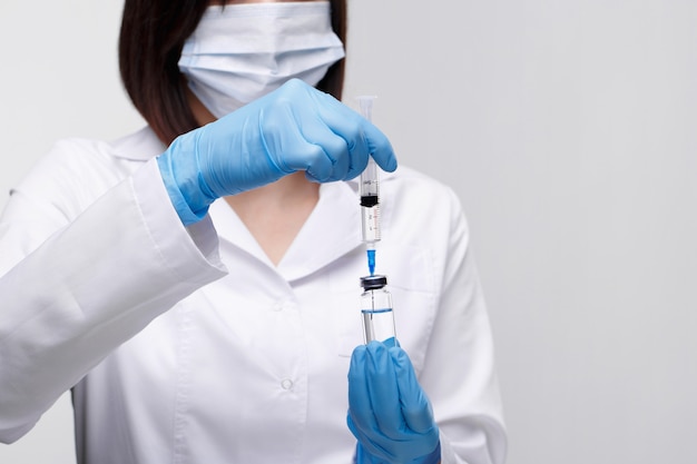 Medical injection,diseases,health care,science,diabetes.Doctor or nurse in hospital holding a syringe with liquid vaccines preparing to do an injection.Medical equipment. People in white uniform,robe