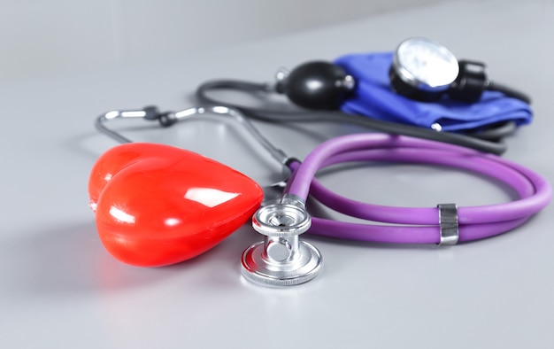 Medical instruments and red heart for ENT doctor on white table