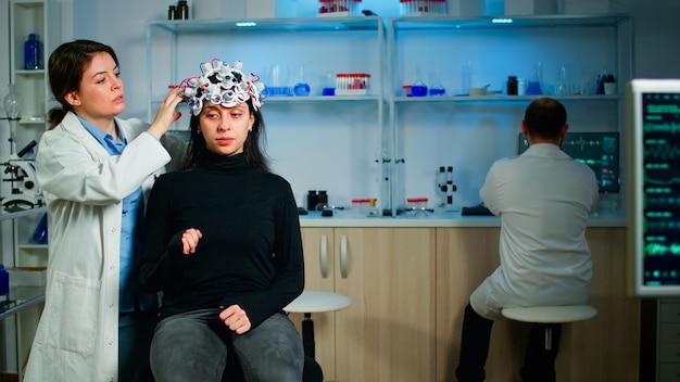 Medical lab technician adjusting eeg headset monitoring brain functions, discovering diagnosis of disease