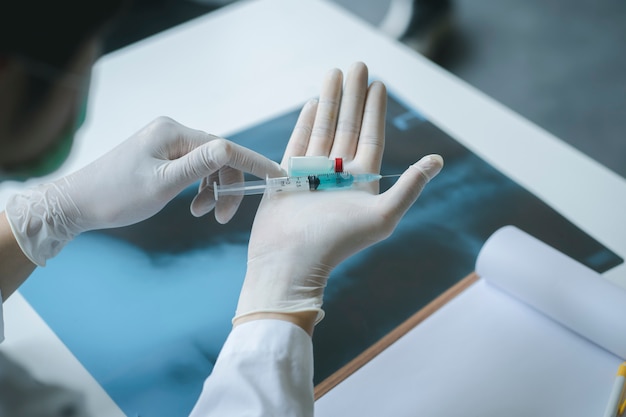 치료 환자를위한 2019-nCoV 백신이 포함 된 의료 실험실 충전 주사기.