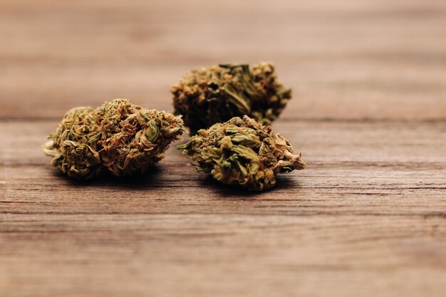 Medical marijuana inflorescences of shinki weed plant on wooden\
background