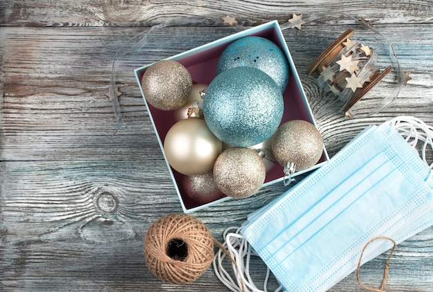 Medical mask and Christmas balls in a box